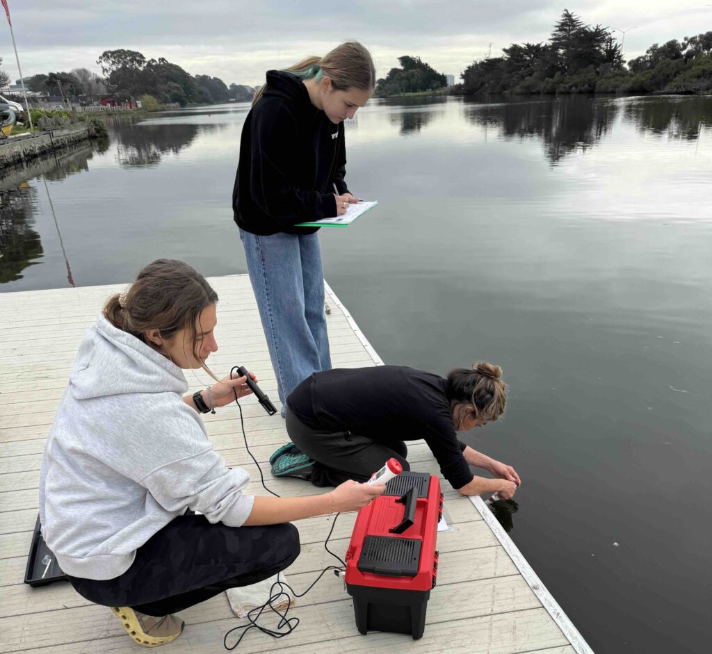Three women sampling water