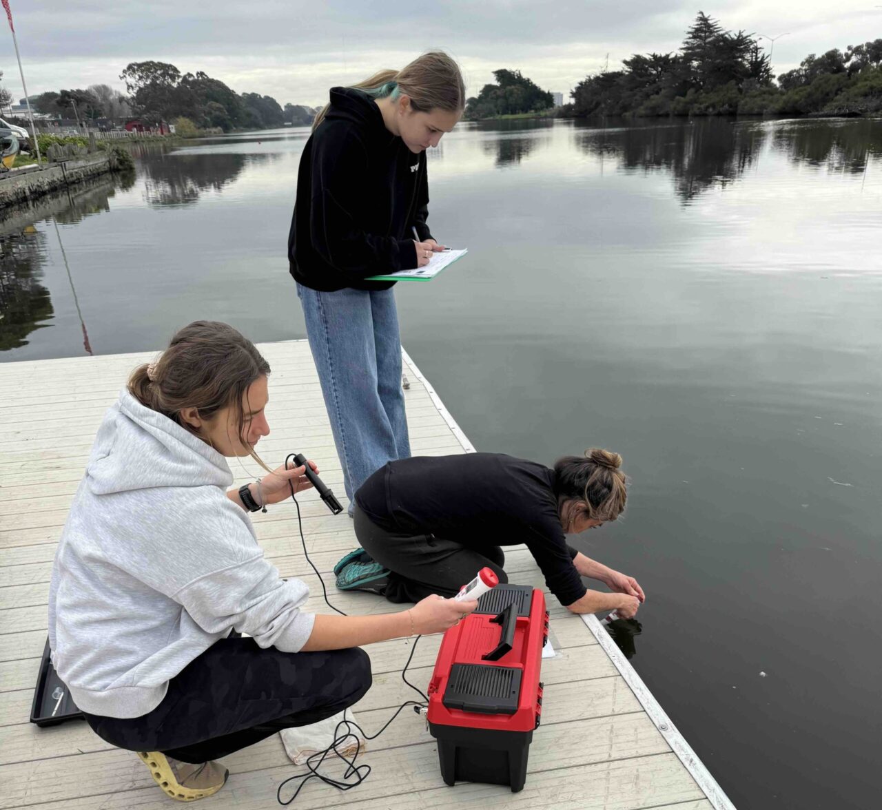 Three women sampling water
